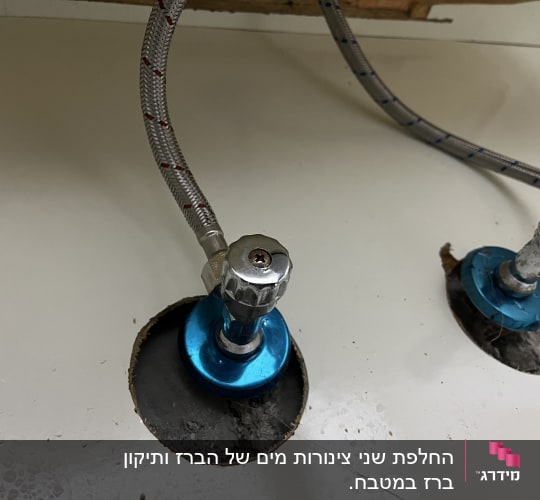 צינורות מים עם ברזים מתחת לכיור